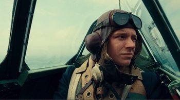 Movie still from “Dunkirk” (2017), directed by Christopher Nolan – A man wearing a pilot's outfit sitting in an airplane; Close Up shot, Low angle