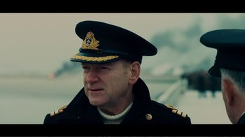 Movie still from “Dunkirk” (2017), directed by Christopher Nolan – A person wearing a hat; Medium shot, Over the shoulder angle