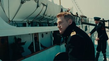 Movie still from “Dunkirk” (2017), directed by Christopher Nolan – A man in a military uniform on a boat; Medium shot, Low angle