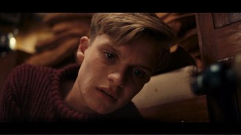 Movie still from “Dunkirk” (2017), directed by Christopher Nolan – A person with a sweater on; Close Up shot, Overhead angle
