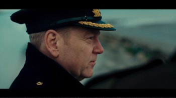 Movie still from “Dunkirk” (2017), directed by Christopher Nolan – A person wearing a hat; Close Up shot, Over the shoulder angle