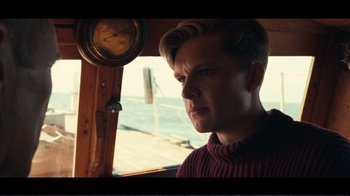 Movie still from “Dunkirk” (2017), directed by Christopher Nolan – A young man is looking out of a boat window; Close Up shot, Low angle