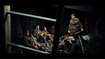 Movie still from “Dunkirk” (2017), directed by Christopher Nolan – A group of men sitting in a room; Wide shot, High angle