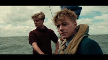 Movie still from “Dunkirk” (2017), directed by Christopher Nolan – Two young men on a sailboat in the ocean; Close Up shot, Low angle