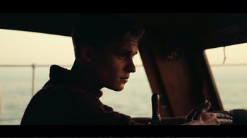 Movie still from “Dunkirk” (2017), directed by Christopher Nolan – A man sitting in a car looking at a phone; Close Up shot, Low angle