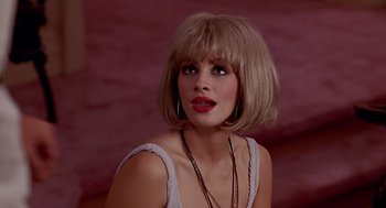 Movie still from “Pretty Woman” (1990), directed by Garry Marshall – A beautiful woman with blonde hair and red lipstick; Close Up shot, Over the shoulder angle
