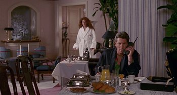 Movie still from “Pretty Woman” (1990), directed by Garry Marshall – A man sitting at a table talking on the phone; Wide shot, Low angle