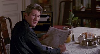 Movie still from “Pretty Woman” (1990), directed by Garry Marshall – A man sitting at a table reading a newspaper; Close Up shot, Over the shoulder angle