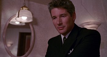 Movie still from “Pretty Woman” (1990), directed by Garry Marshall – A person wearing a suit and tie; Close Up shot, Over the shoulder angle