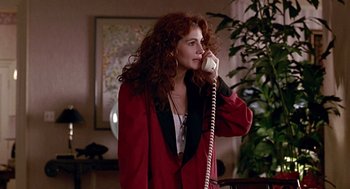 Movie still from “Pretty Woman” (1990), directed by Garry Marshall – A woman talking on a phone while standing in a room; Medium shot, Over the shoulder angle