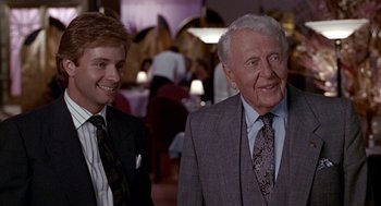 Movie still from “Pretty Woman” (1990), directed by Garry Marshall – Two men in suits and ties standing next to each other; Medium shot, Over the shoulder angle