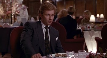 Movie still from “Pretty Woman” (1990), directed by Garry Marshall – A man sitting at a table with a plate in front of him; Medium shot, Over the shoulder angle