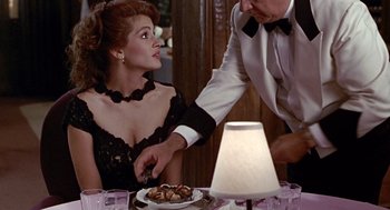 Movie still from “Pretty Woman” (1990), directed by Garry Marshall – A man and a woman sitting at a dinner table; Medium shot, Over the shoulder angle