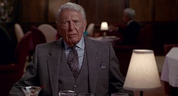 Movie still from “Pretty Woman” (1990), directed by Garry Marshall – An older man in a suit and tie sitting at a table; Close Up shot, Over the shoulder angle