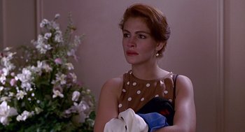 Movie still from “Pretty Woman” (1990), directed by Garry Marshall – A woman in a brown polka dot dress holding a towel; Close Up shot, Over the shoulder angle