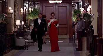 Movie still from “Pretty Woman” (1990), directed by Garry Marshall – A man and a woman in a red dress walking down a hall way; Wide shot, Low angle