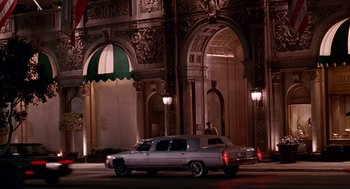 Movie still from “Pretty Woman” (1990), directed by Garry Marshall – A car parked on the side of the road near a building; Extreme Wide shot, Low angle