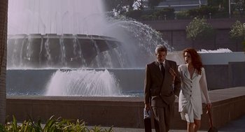Movie still from “Pretty Woman” (1990), directed by Garry Marshall – A man and a woman walking in front of a fountain; Wide shot, Low angle