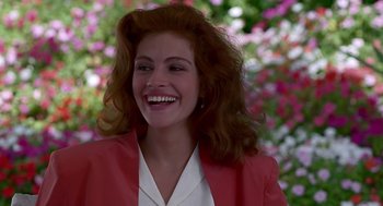 Movie still from “Pretty Woman” (1990), directed by Garry Marshall – A woman in a red jacket smiling for the camera; Close Up shot, Over the shoulder angle