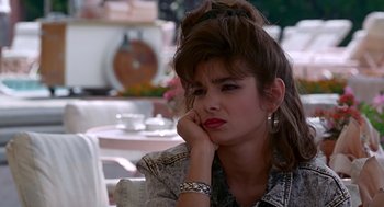 Movie still from “Pretty Woman” (1990), directed by Garry Marshall – A woman sitting at a table with her hand under her chin; Close Up shot, Over the shoulder angle