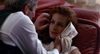 Movie still from “Pretty Woman” (1990), directed by Garry Marshall – A man fixing a woman's hair while she looks at the camera; Close Up shot, Over the shoulder angle