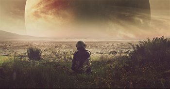 A person sitting on top of a grass covered field