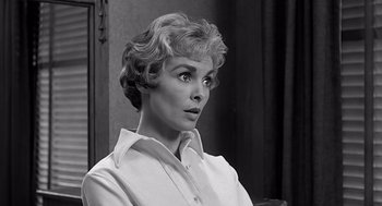Movie still from “Psycho” (1960), directed by Alfred Hitchcock – An old photo of a woman in a white shirt; Close Up shot, Low angle