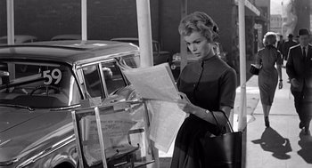 Movie still from “Psycho” (1960), directed by Alfred Hitchcock – A black and white photo of a woman reading a newspaper; Medium shot, Low angle