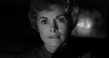 Movie still from “Psycho” (1960), directed by Alfred Hitchcock – An older woman with big eyes stares at the camera; Close Up shot, Low angle