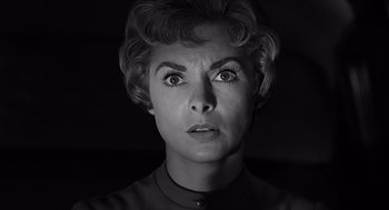 Movie still from “Psycho” (1960), directed by Alfred Hitchcock – An older woman looking surprised in a black and white photo; Close Up shot, Low angle
