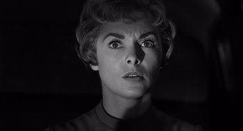 Movie still from “Psycho” (1960), directed by Alfred Hitchcock – An old photo of a woman with a surprised look on her face; Close Up shot, Low angle