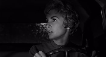 Movie still from “Psycho” (1960), directed by Alfred Hitchcock – A black - and - white photo of a woman holding a steering wheel; Close Up shot, Low angle