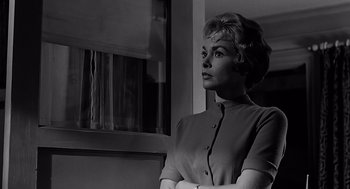 Movie still from “Psycho” (1960), directed by Alfred Hitchcock – A black and white photo of a woman standing in front of a window; Close Up shot, Low angle