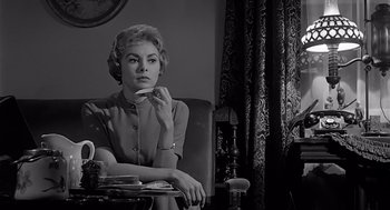 Movie still from “Psycho” (1960), directed by Alfred Hitchcock – A woman sitting in a chair in front of a window; Medium shot, Low angle