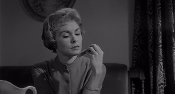 Movie still from “Psycho” (1960), directed by Alfred Hitchcock – An older woman is looking down at a piece of paper; Close Up shot, Low angle