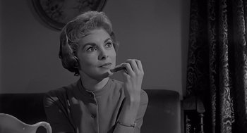 Movie still from “Psycho” (1960), directed by Alfred Hitchcock – An older woman holding a pen in her mouth; Close Up shot, Low angle