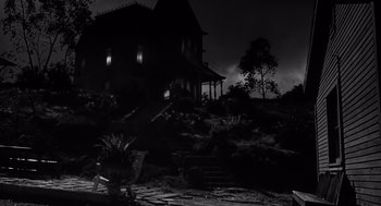 Movie still from “Psycho” (1960), directed by Alfred Hitchcock – A black - and - white photo of a house at night; Extreme Wide shot, Low angle