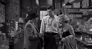 Movie still from “Psycho” (1960), directed by Alfred Hitchcock – A group of people standing next to each other in a room; Medium shot, High angle