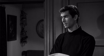 Movie still from “Psycho” (1960), directed by Alfred Hitchcock – Black and white photograph of a young man in a room; Close Up shot, Over the shoulder angle