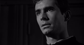 Movie still from “Psycho” (1960), directed by Alfred Hitchcock – Black and white photograph of a man looking into the distance; Close Up shot, Over the shoulder angle