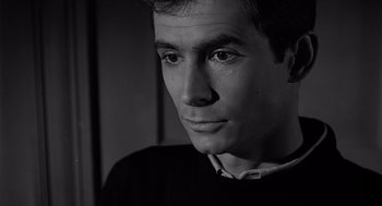 Movie still from “Psycho” (1960), directed by Alfred Hitchcock – Black and white photograph of a young man looking at the camera; Close Up shot, High angle
