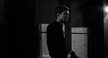 Movie still from “Psycho” (1960), directed by Alfred Hitchcock – A black and white photo of a man in a black shirt; Close Up shot, Low angle