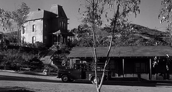 Movie still from “Psycho” (1960), directed by Alfred Hitchcock – An old truck parked in front of an old house; Extreme Wide shot, Low angle