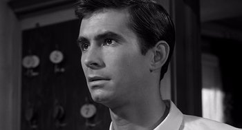 Movie still from “Psycho” (1960), directed by Alfred Hitchcock – Black and white photograph of a young man looking into the distance; Close Up shot, Over the shoulder angle