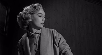 Movie still from “Psycho” (1960), directed by Alfred Hitchcock – An old photo of a woman in a coat looking to her left; Close Up shot, Low angle