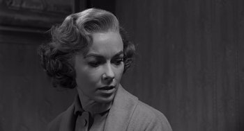 Movie still from “Psycho” (1960), directed by Alfred Hitchcock – An old photo of a woman in a suit looking to her left; Close Up shot, Over the shoulder angle