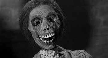 Movie still from “Psycho” (1960), directed by Alfred Hitchcock – A creepy looking doll with a creepy face; Close Up shot, Low angle