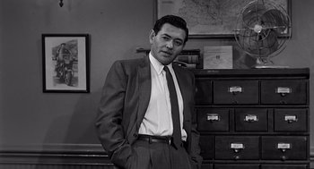 Movie still from “Psycho” (1960), directed by Alfred Hitchcock – Black and white photograph of a man in a suit and tie; Medium shot, Low angle