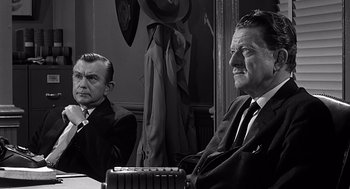 Movie still from “Psycho” (1960), directed by Alfred Hitchcock – Two men sitting at a table in front of a mirror; Medium shot, Over the shoulder angle