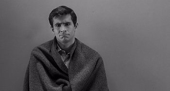 Movie still from “Psycho” (1960), directed by Alfred Hitchcock – A black and white photo of a man wrapped in a blanket; Close Up shot, High angle